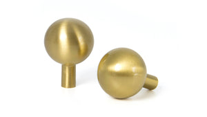 Small curved brass knobs in Satin Brass